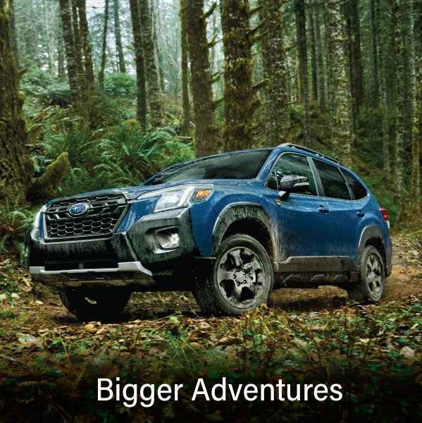 A blue Subaru outback wilderness with the words &ldquo;Bigger Adventures&ldquo;. | John Kennedy Subaru in Plymouth Meeting PA
