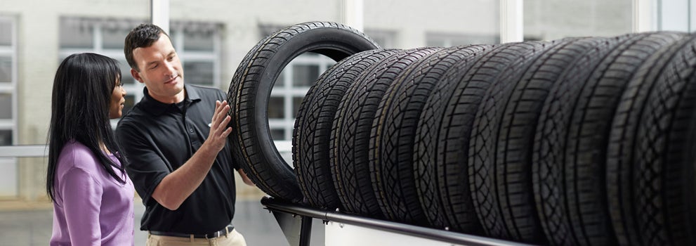 Subaru service representative showing customer a tire. | John Kennedy Subaru in Plymouth Meeting PA