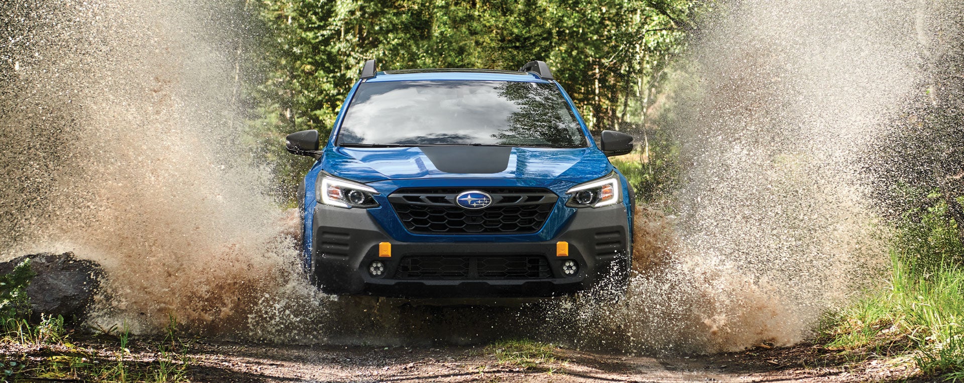 A 2023 Outback Wilderness driving on a muddy trail. | John Kennedy Subaru in Plymouth Meeting PA